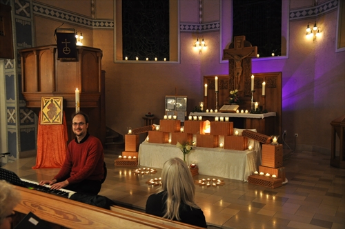 Der Altar der Erlöserkirche war mit kunstvoll aufgebauten Kerzen geschmückt. Im Vordergrund Domorganist Martin Nyqyist (Foto: Ernst)