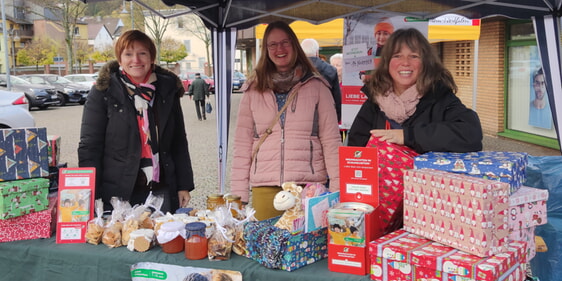 Wie hier Manuela Winkemann (r.) mit ihrem Team auf dem Plettenberger Wochenmarkt sind noch viele Weihnachtswichtel im Kirchenkreis für „Weihnachten im Schuhkarton“ im Einsatz (Foto: EKGP)