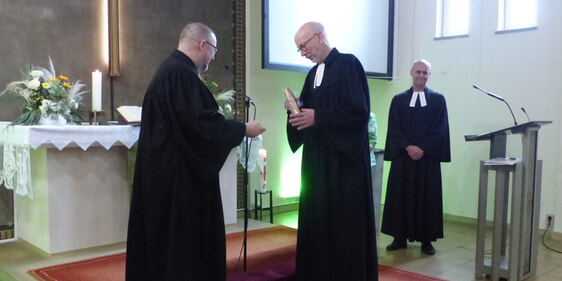 Superintendent Dr. Christoph Grote (l.) nahm im Auftrag des hiesigen Kirchenkreises die offizielle Entpflichtung von Pfarrer Reiner Fröhlich (m.) vom Amt des Pfarrers und damit die Verabschiedung des langjährigen Kiersper Geistlichen in den Ruhestand vor (Foto: Rainer Crummenerl)