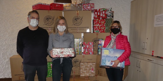 Jutta Ottofülling (l.), ihr Ehemann Thomas und eine Helferin (r.) mit Weihnachtspäckchen für die diesjährige Aktion „Weihnachten im Schuhkarton“, von denen über 300 in der Markuskirche zusammengekommen waren und dort in große Kisten gepackt wurden (Foto: Weiland)