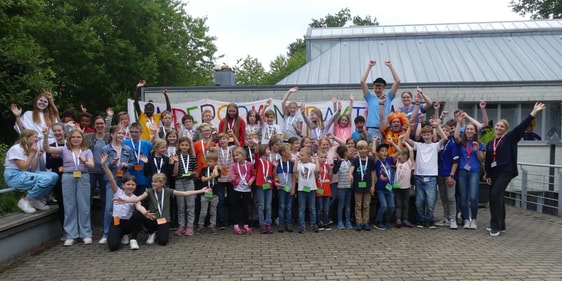 Gruppenfoto von allen an den Sommerferienaktionen des CVJM Brügge beteiligten Kindern und Mitarbeitenden vor dem Gemeindezentrum Lösenbach. (Foto: Ingrid Weiland)
